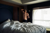 Person in bed touching neck in the morning